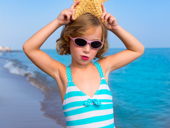 child kid girl in summer beach vacations with starfish and aqua sea